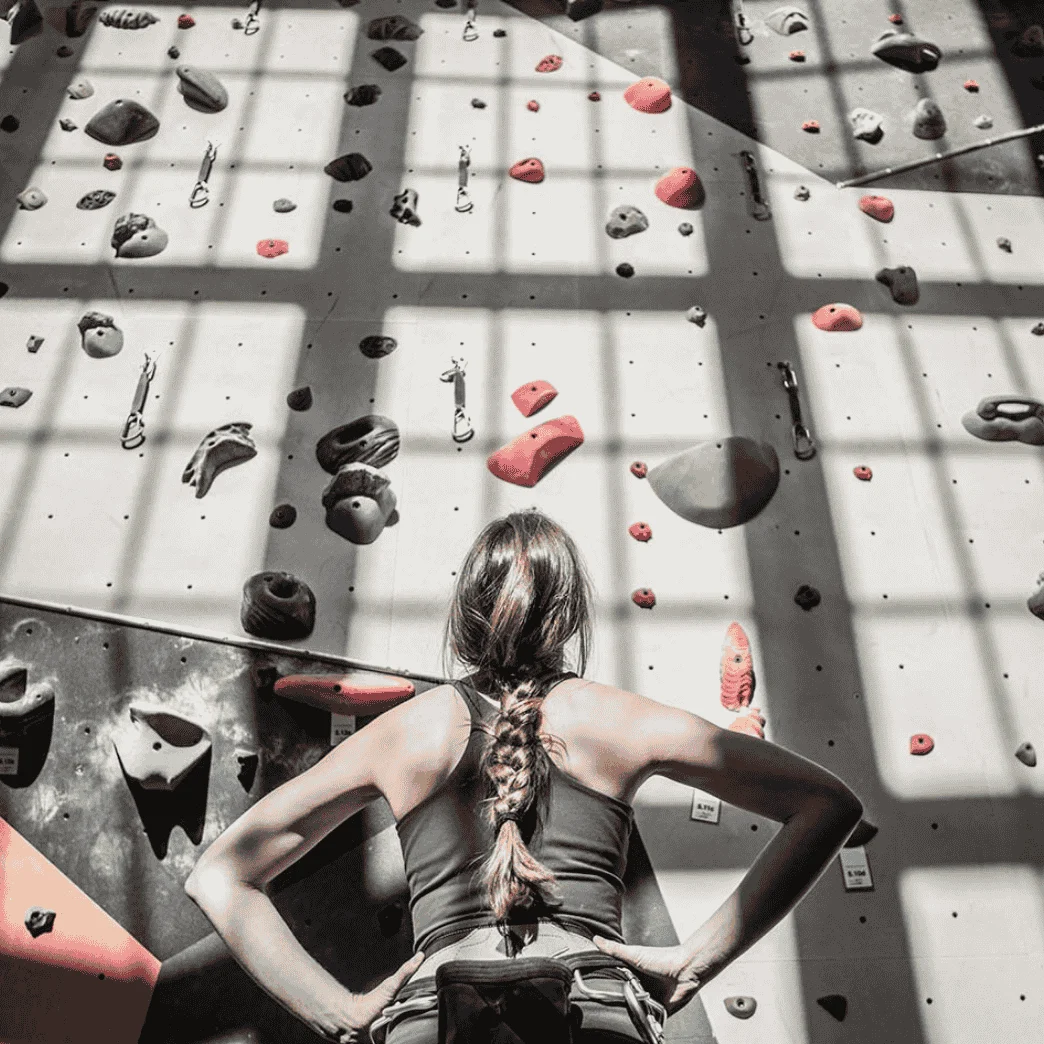 woman looking at climbing wall