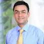 Profile image of Rahul Goyal, MD smiling and wearing a blue dress shirt and yellow tie.