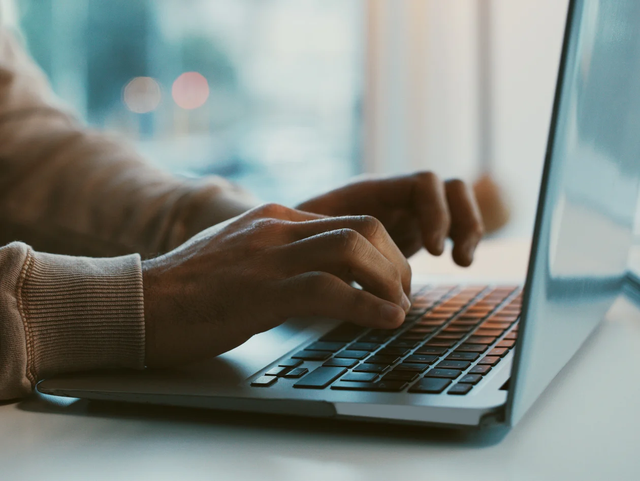 Up close image of hands typing on a laptop