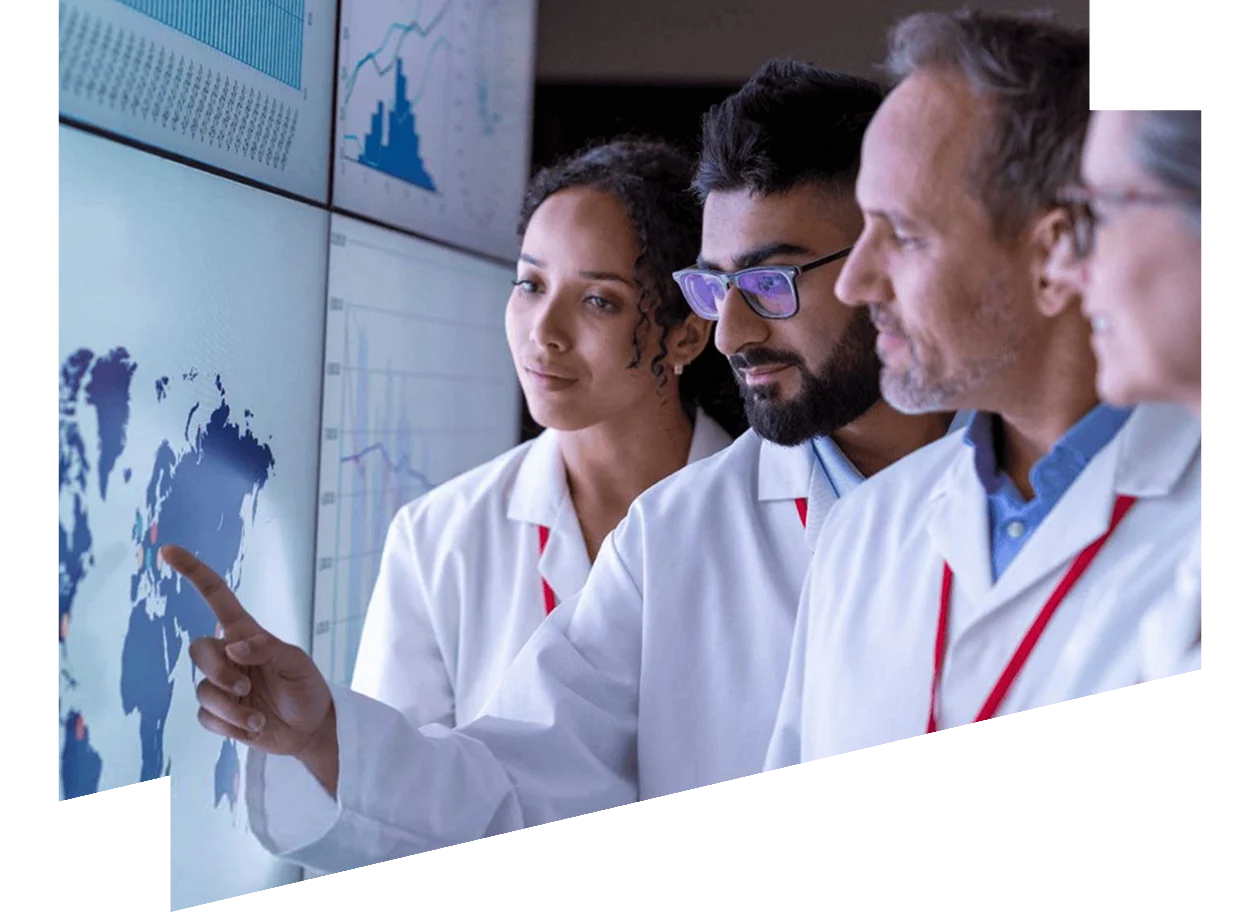 Group of people wearing white coats looking at a digital screen