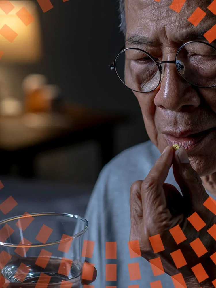 Asian senior man taking medication in bed room