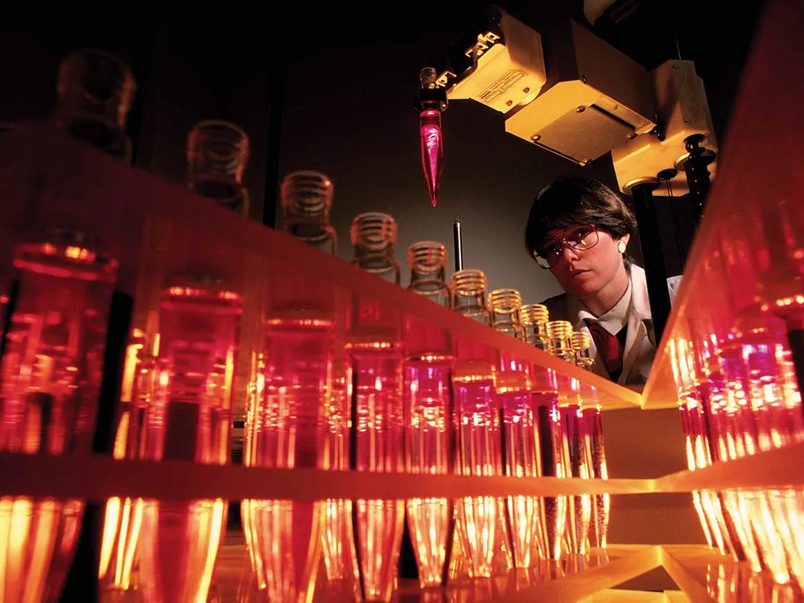 Scientist in lab over looking vials