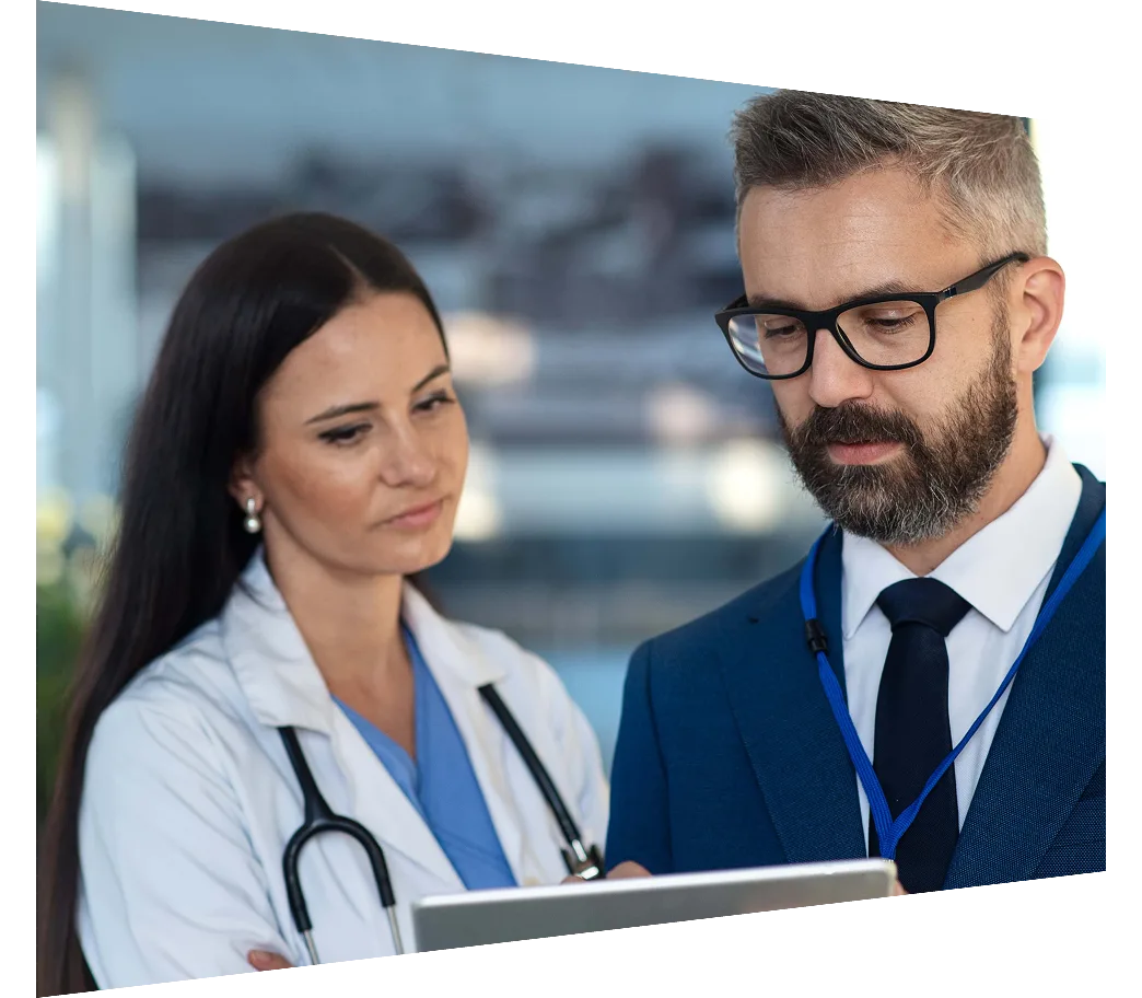 Businessman and doctor looking at digital tablet in hospital corridor