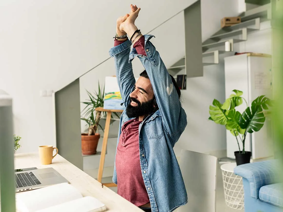 man stretches while working