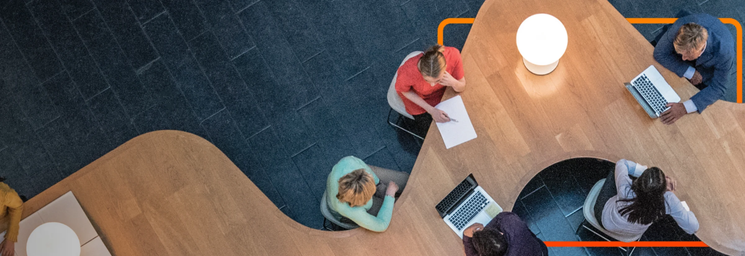 Group of people around a table with laptops 