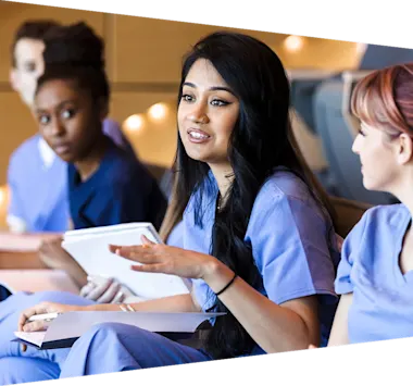 Young adult female nursing student gestures while asking a question in class