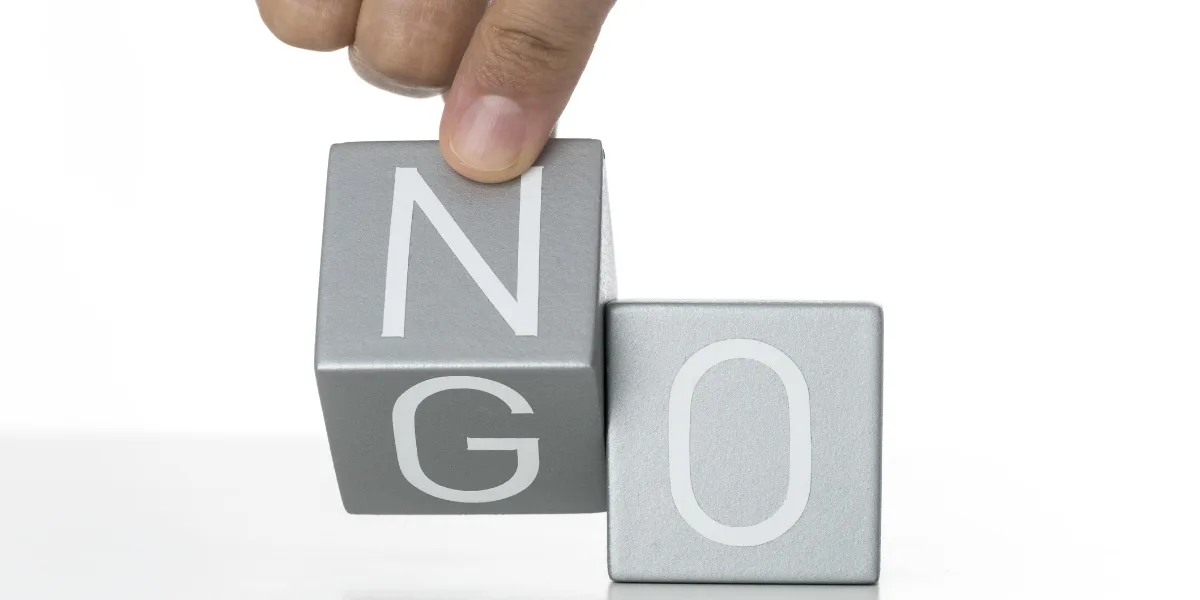 Hand changing the letter N to G of the word NO on gray blocks
