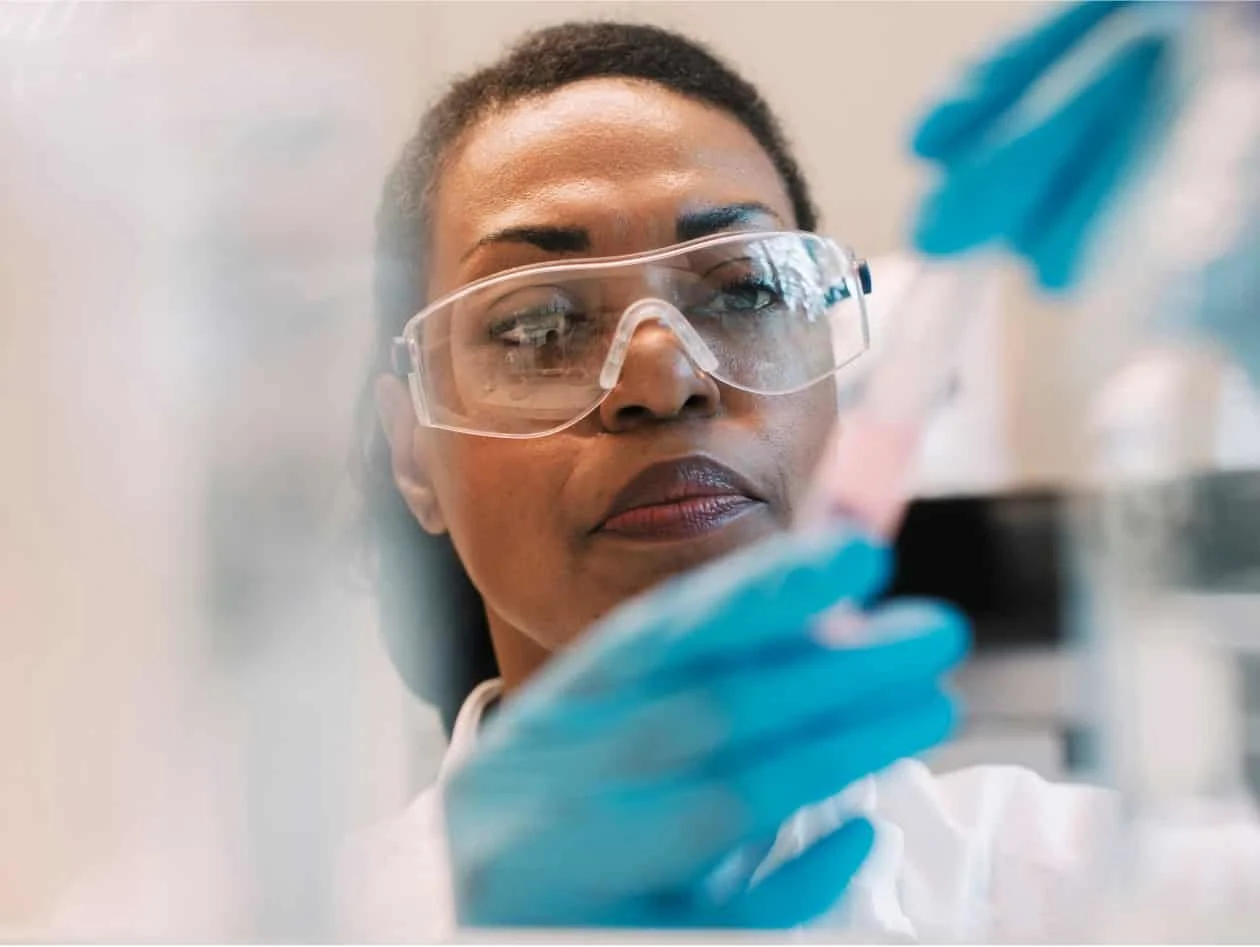 Female scientist looking at chemistry flask