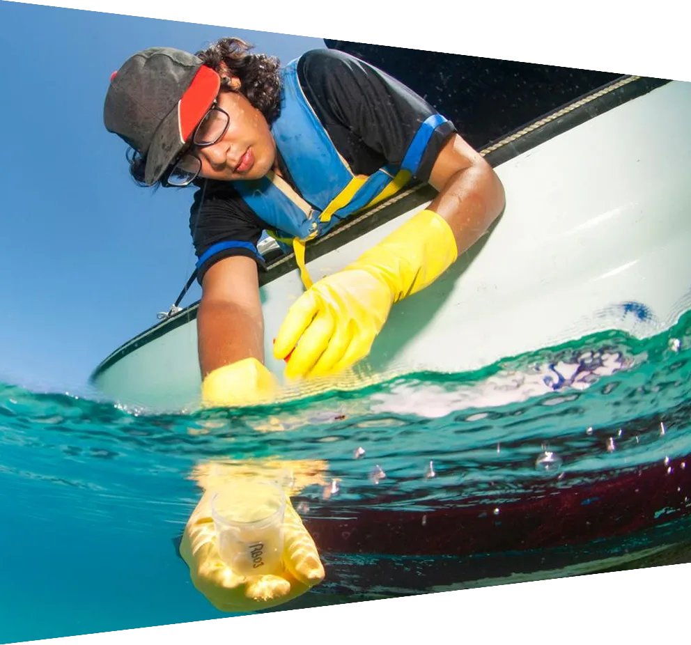 Marine Biologist taking samples of water from a boat for water quality test