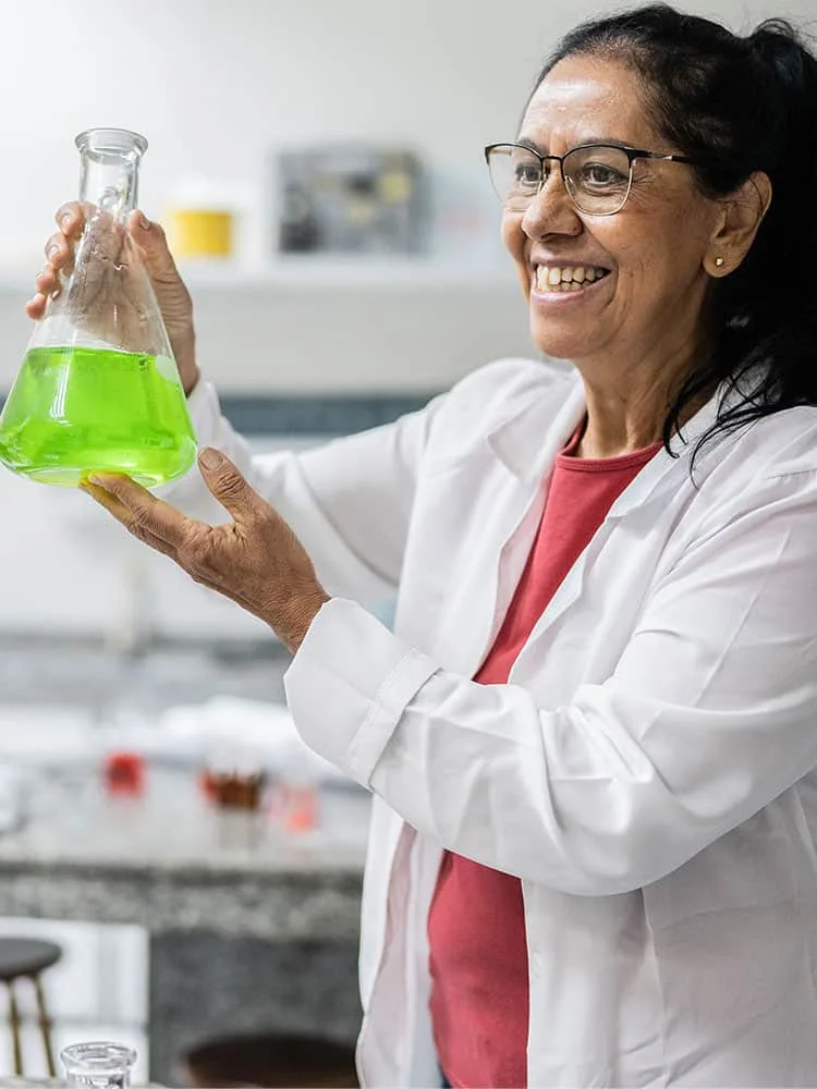 Gender and Diversity in Research - Portrait image - Women smiling and holding scientific flask