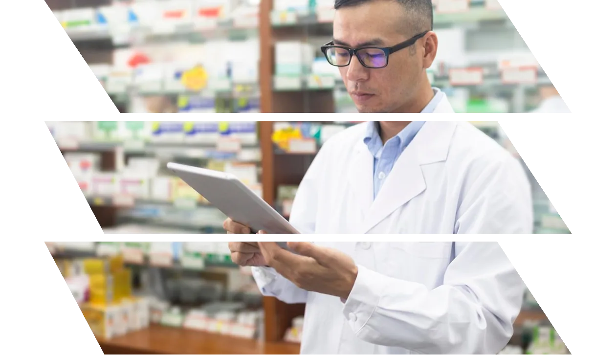 A female doctor looking at a tablet while holding a medicine in a pharmacy.