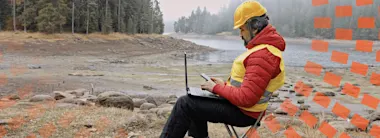Man using laptop on snowy mountain 