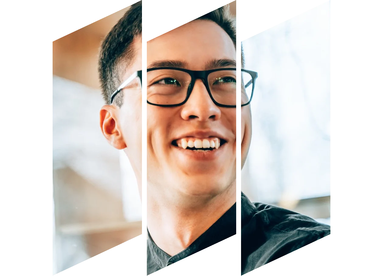 A man with glasses smiling brightly.