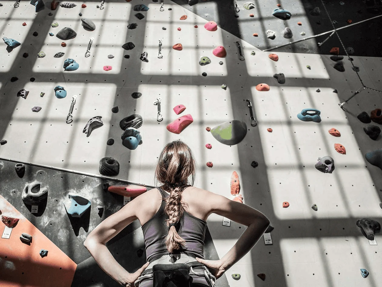 woman looking at climbing wall