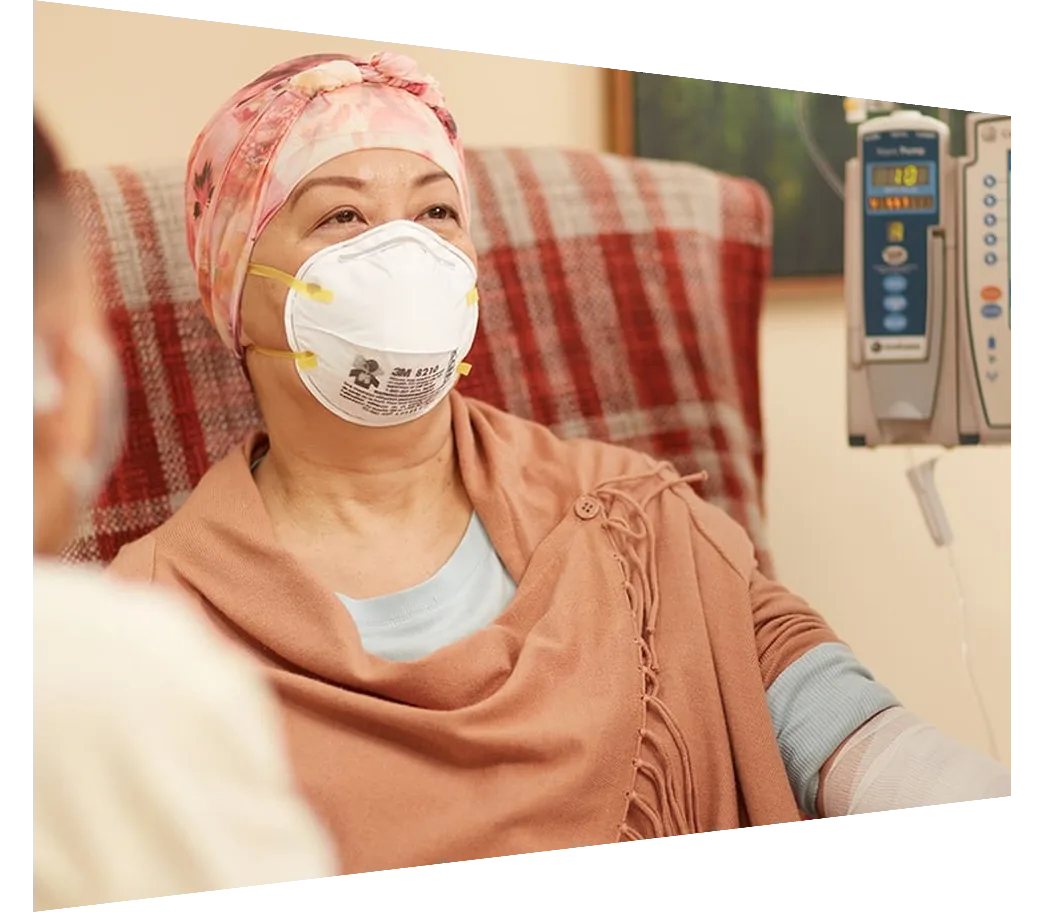 Seated patient in mask with family member and physician