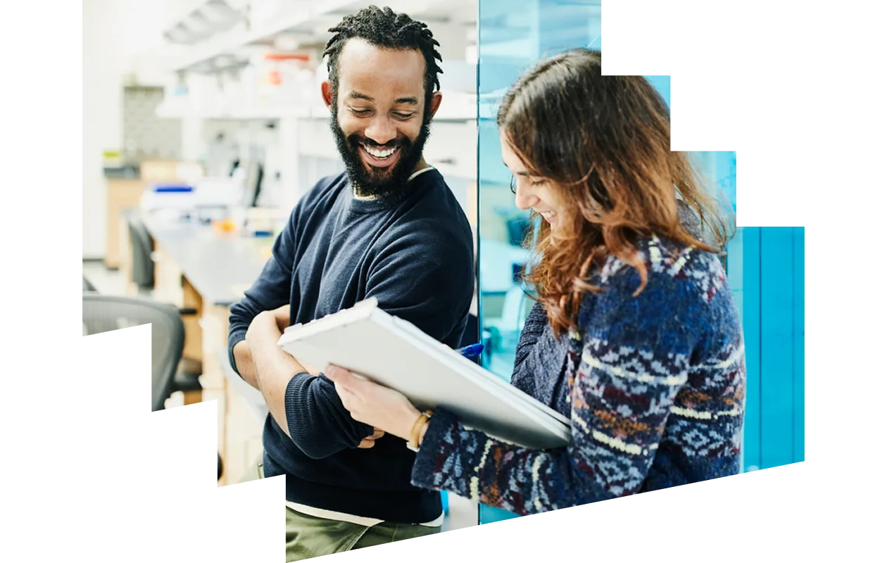 Smiling scientists in discussion while filling out paperwork in research lab