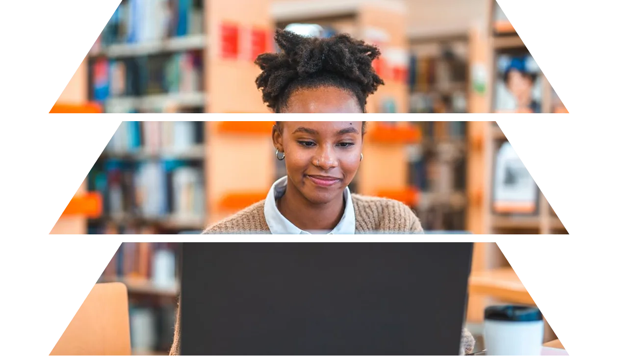Young Hispanic female student using a laptop in a library
