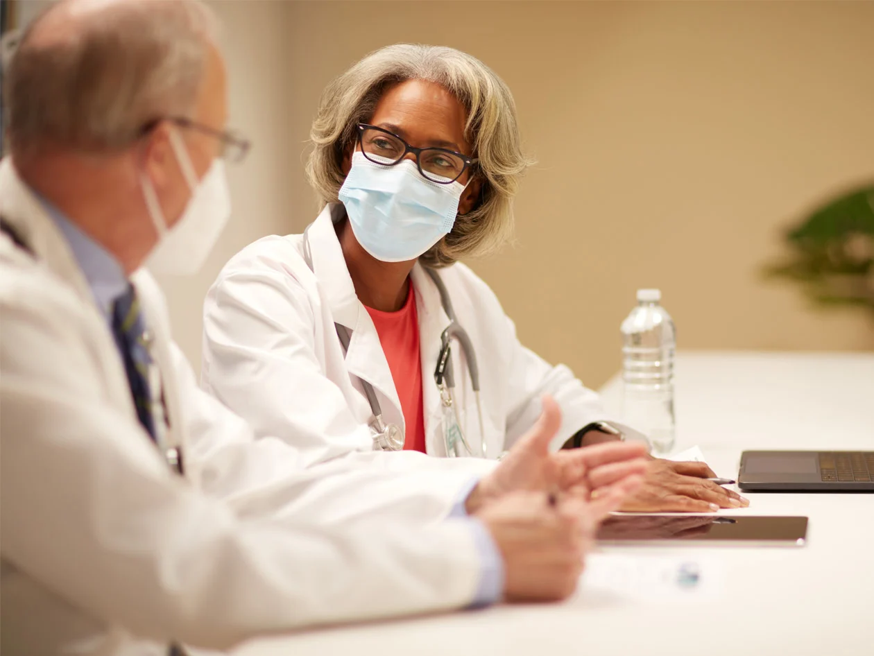 Two doctors in masks having a conversation