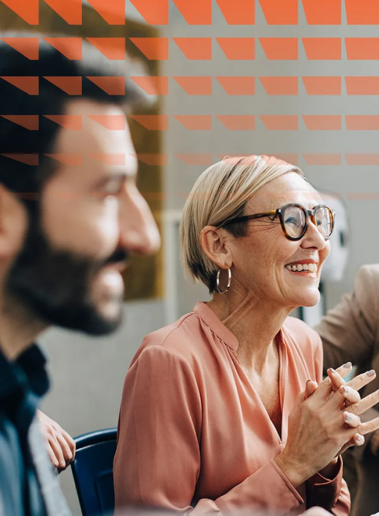 Smiling business people discussing during meeting in board room at corporate office