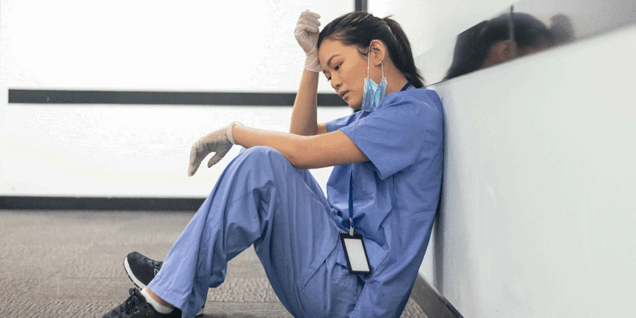 exhausted clinician resting on hospital floor