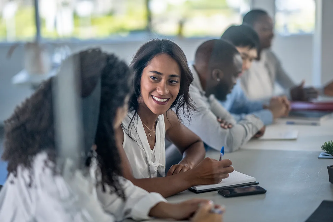 Five students sitting at a long table or desk at a lecture.