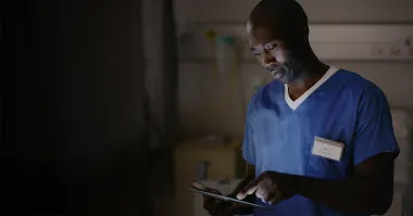 A nurse scrolling through a tablet