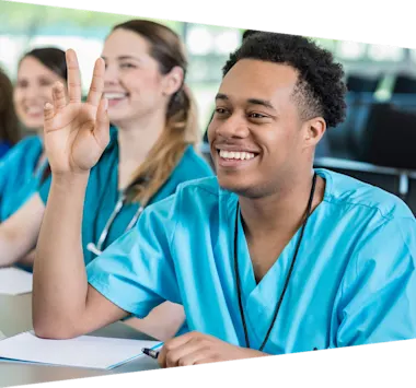 Attentive young African American male nursing student listening to professor in class