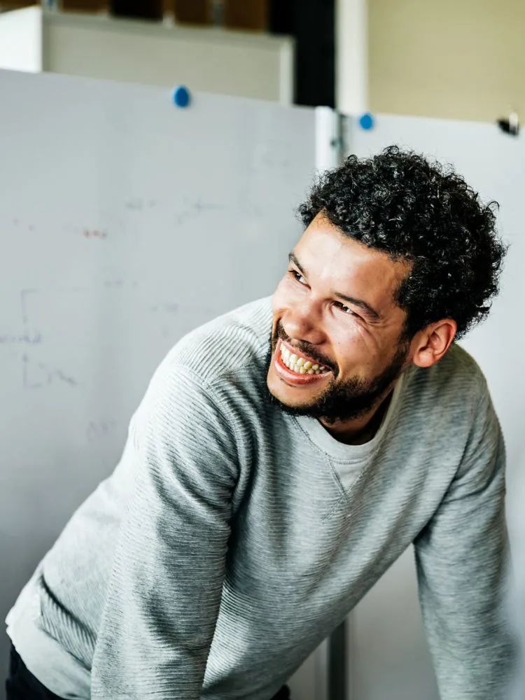 Research Integrity image - man laughing in sweater, laughing with colleagues