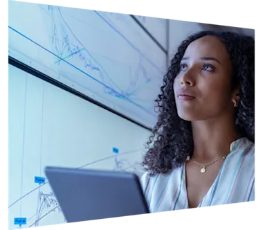 Female researcher with tablet in front of screen with analytics 