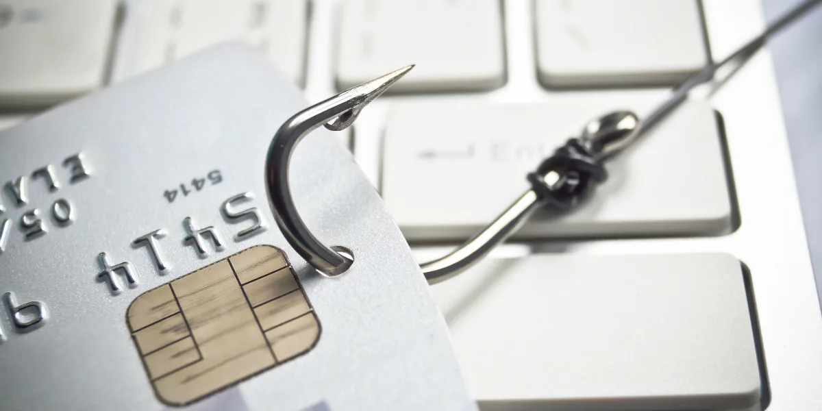 Fish hook with a credit card on white computer keyboard