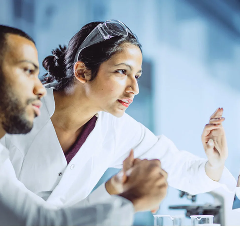 Two lab technicians collaborating on a touch-screen monitor