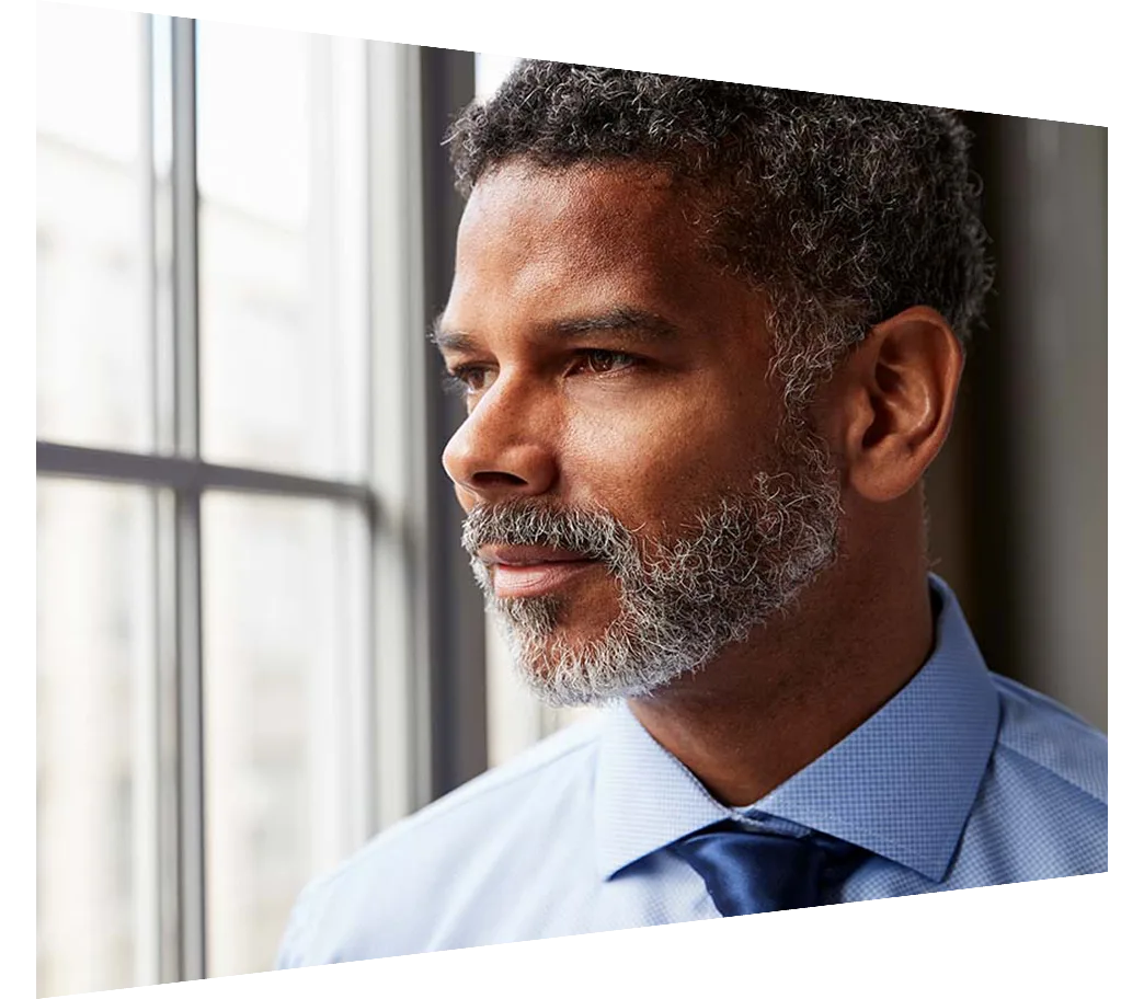 A corporate man looking out of an office window