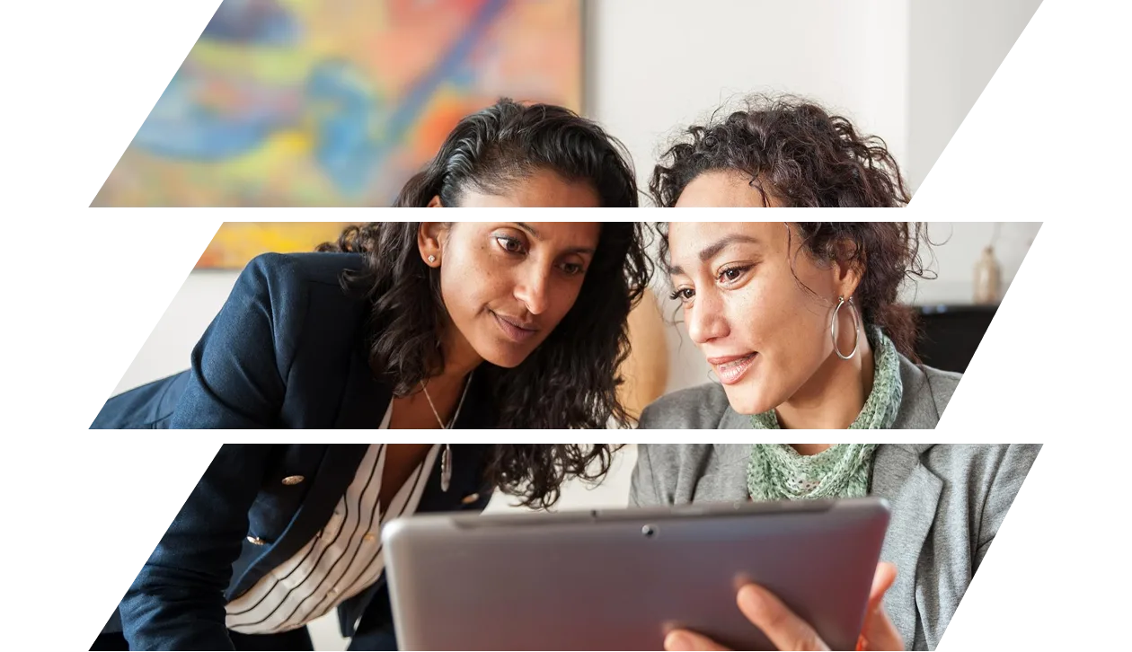 Two business women looking at a digital tablet, discussing a topic