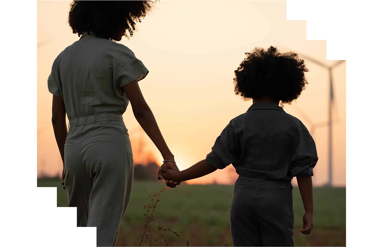 Parent taking their child to visit and admire renewable energy windmills