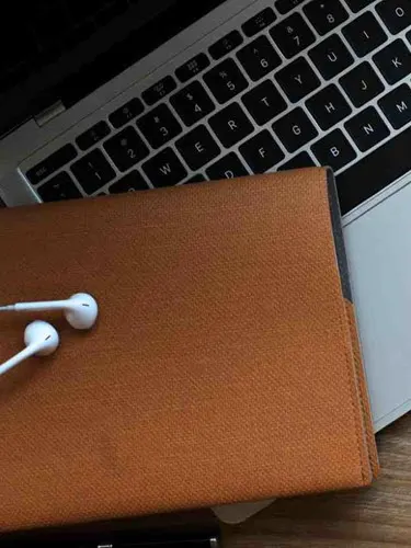 Earphones, wallet and a keyboard on a desk