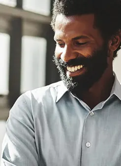 Man smiling next to window