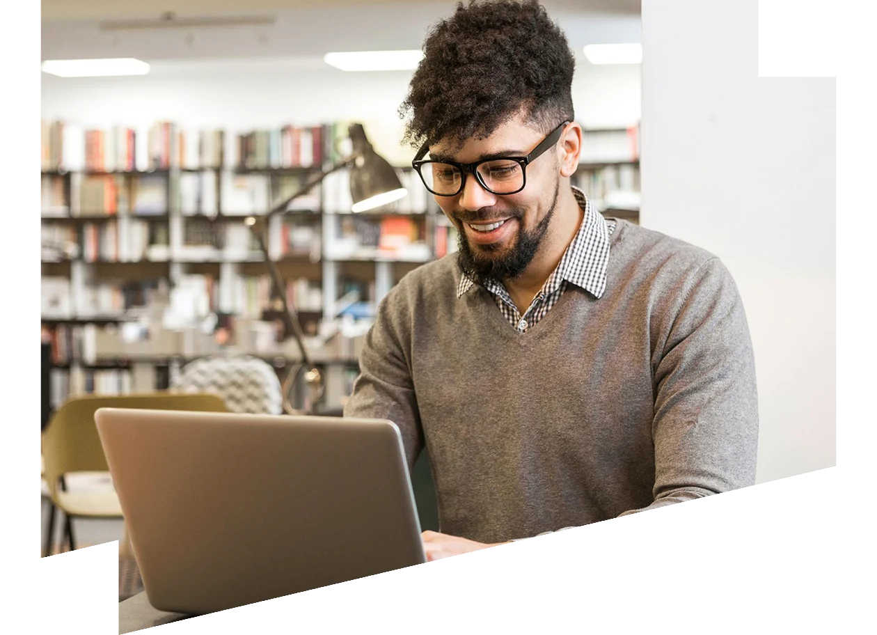 Young man working on his laptop in a library 