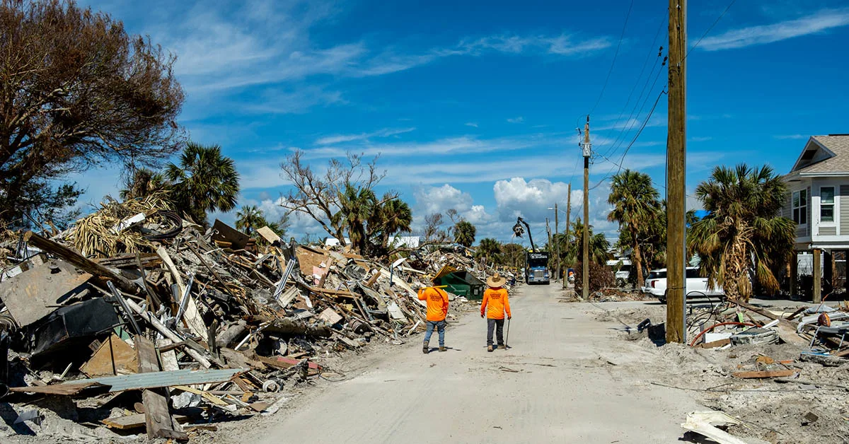Workers walk along debris on Fort Myers Beach, Florida, after Hurricane Ian in 2022. (© istock.com/Jeff McCollough)
