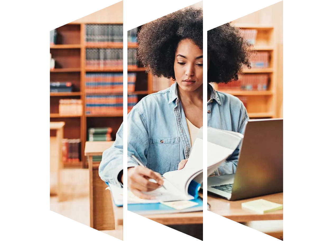 Young female students taking notes in a library