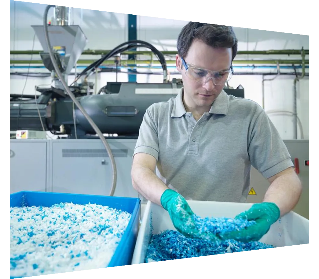Worker inspecting recycled plastic in plastics factory