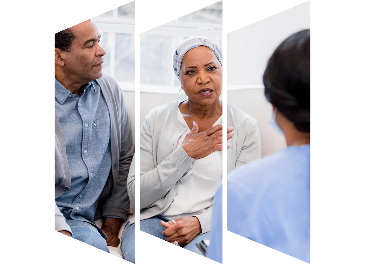 Senior woman holds her chest while talking to a nurse