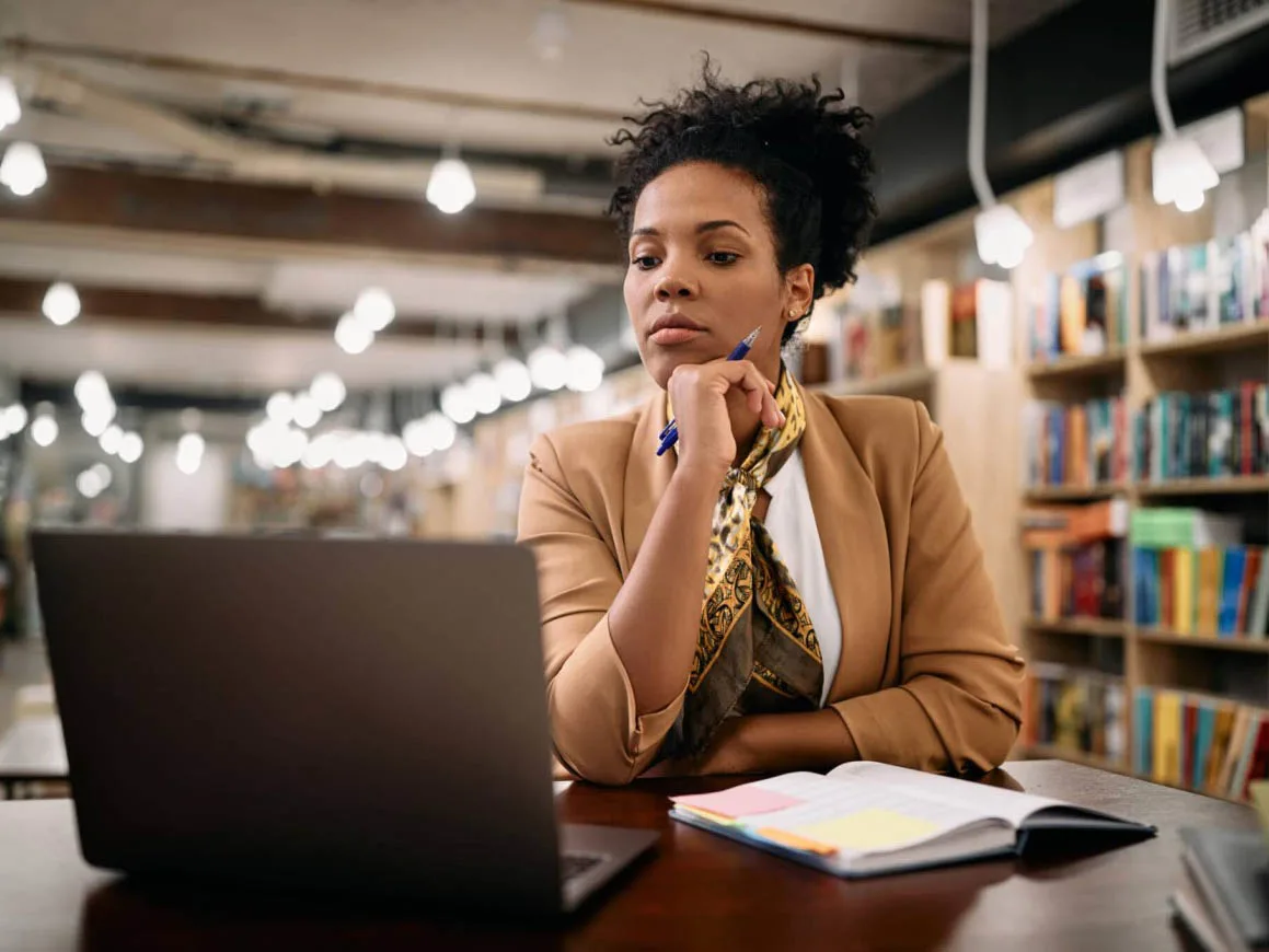 Woman studying in library with laptop