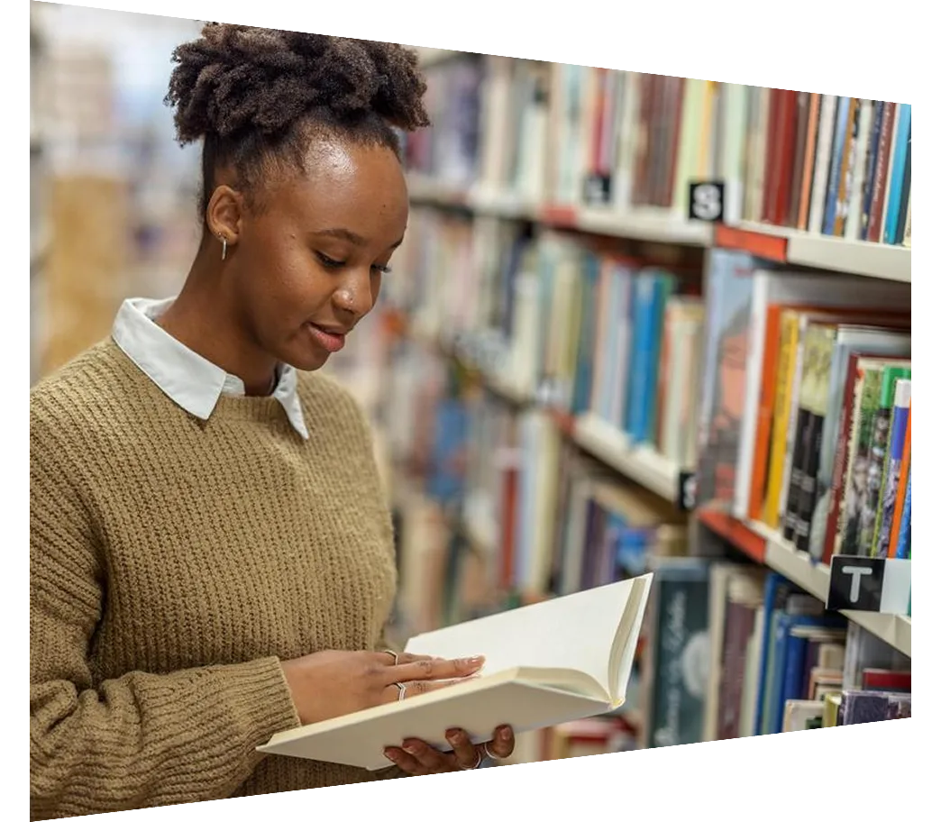 Young African-American Student Reading A Book In The Library