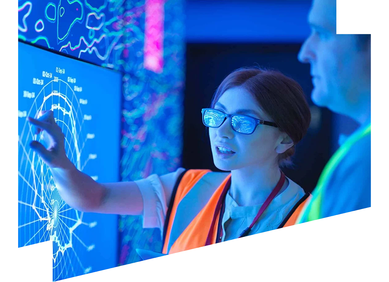 Two engineers examining geological data on a digital screen