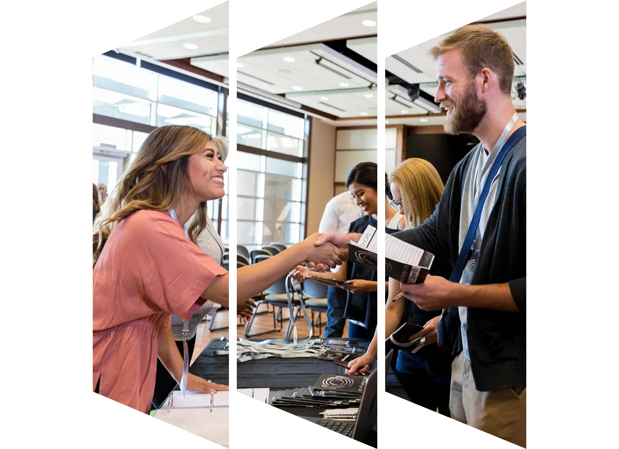 Woman at a conference registration table greeting an associate