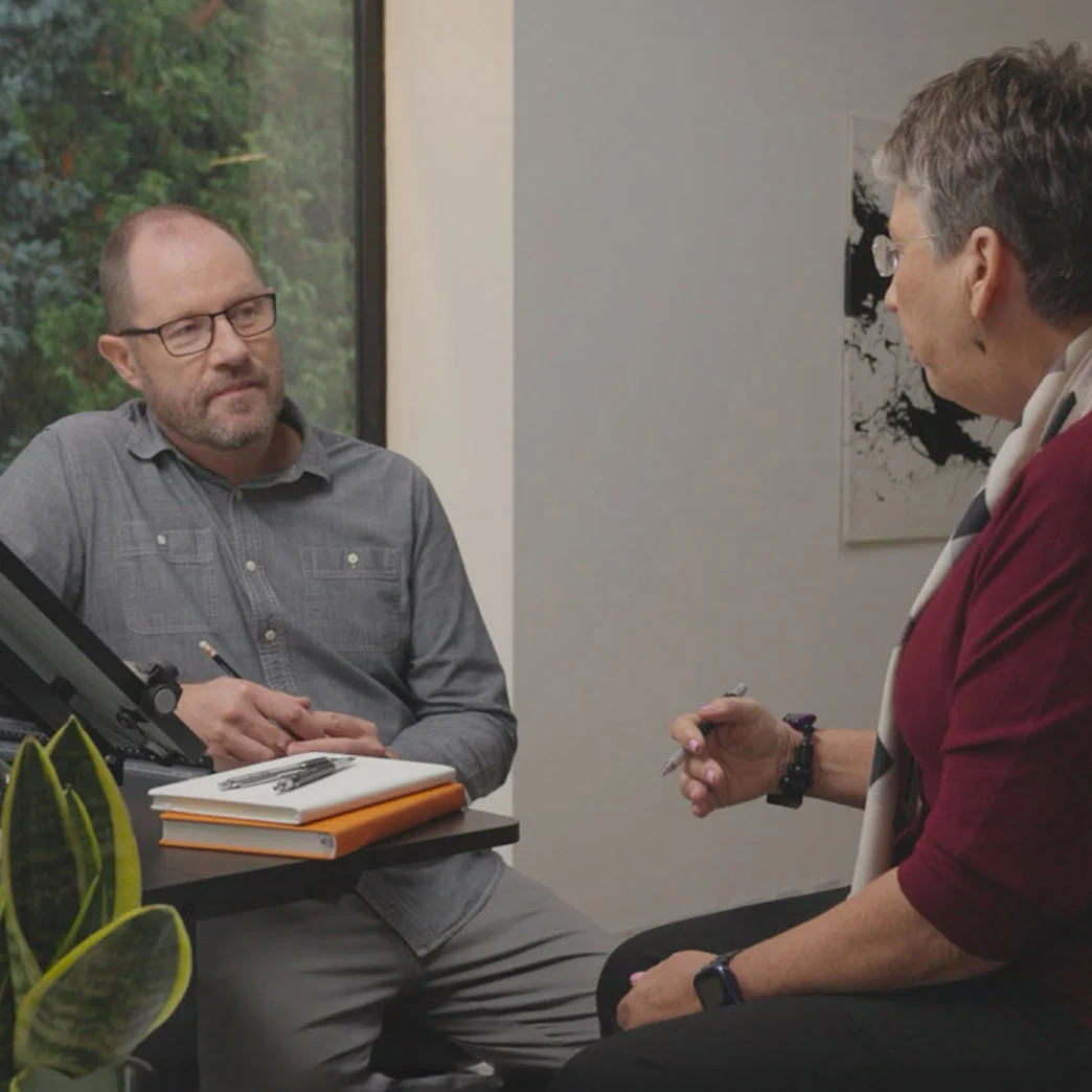 Two persons having a meeting while sitting on a chair