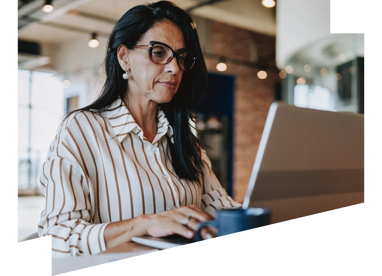 Mature businesswoman working on laptop in modern office