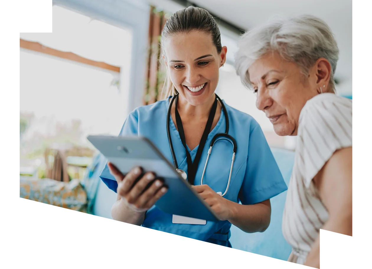 Home care healthcare professional using a digital tablet standing next to a patient