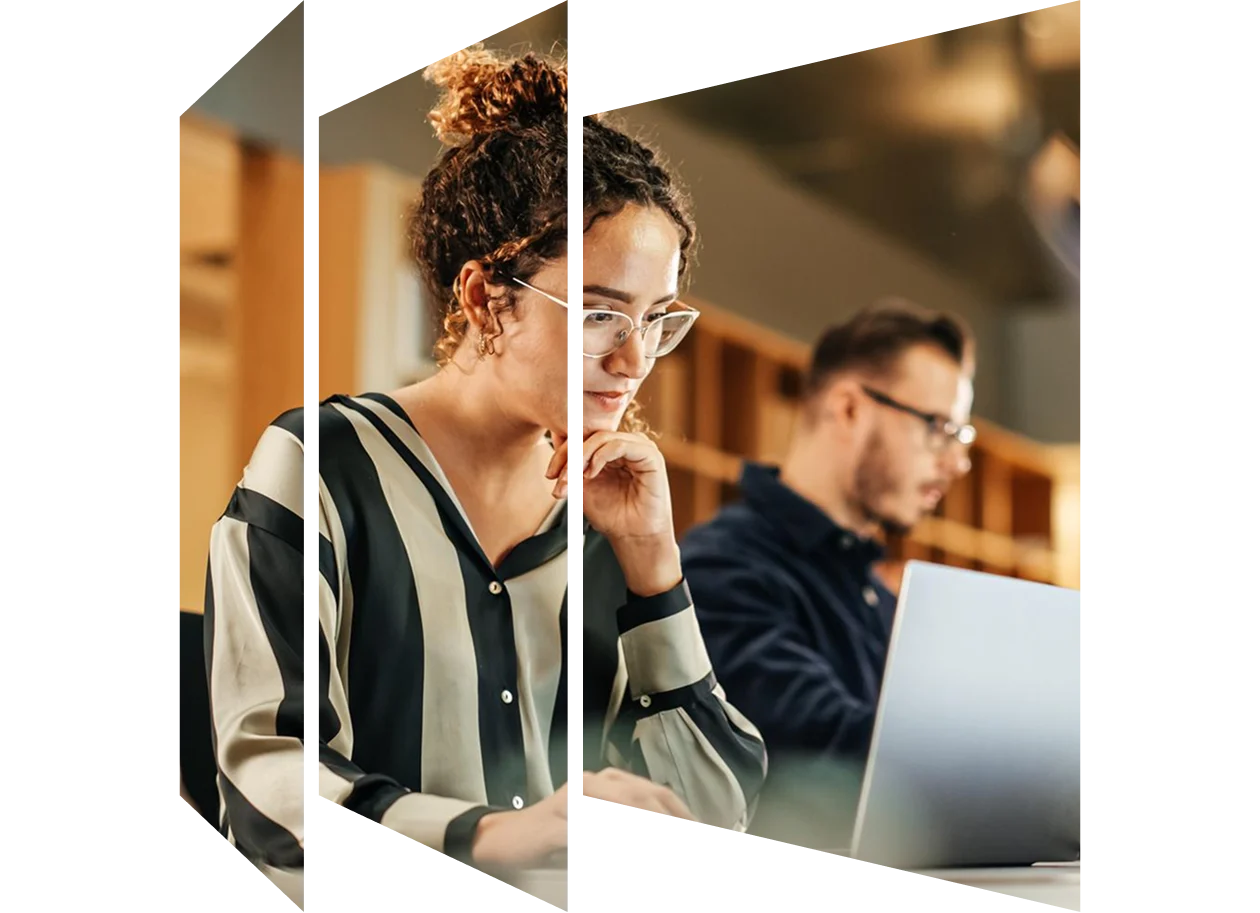 Enthusiastic Hispanic young woman working on computer in a modern office