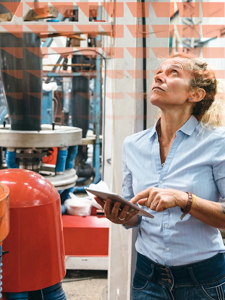 Female engineer inspecting machinery in a factory